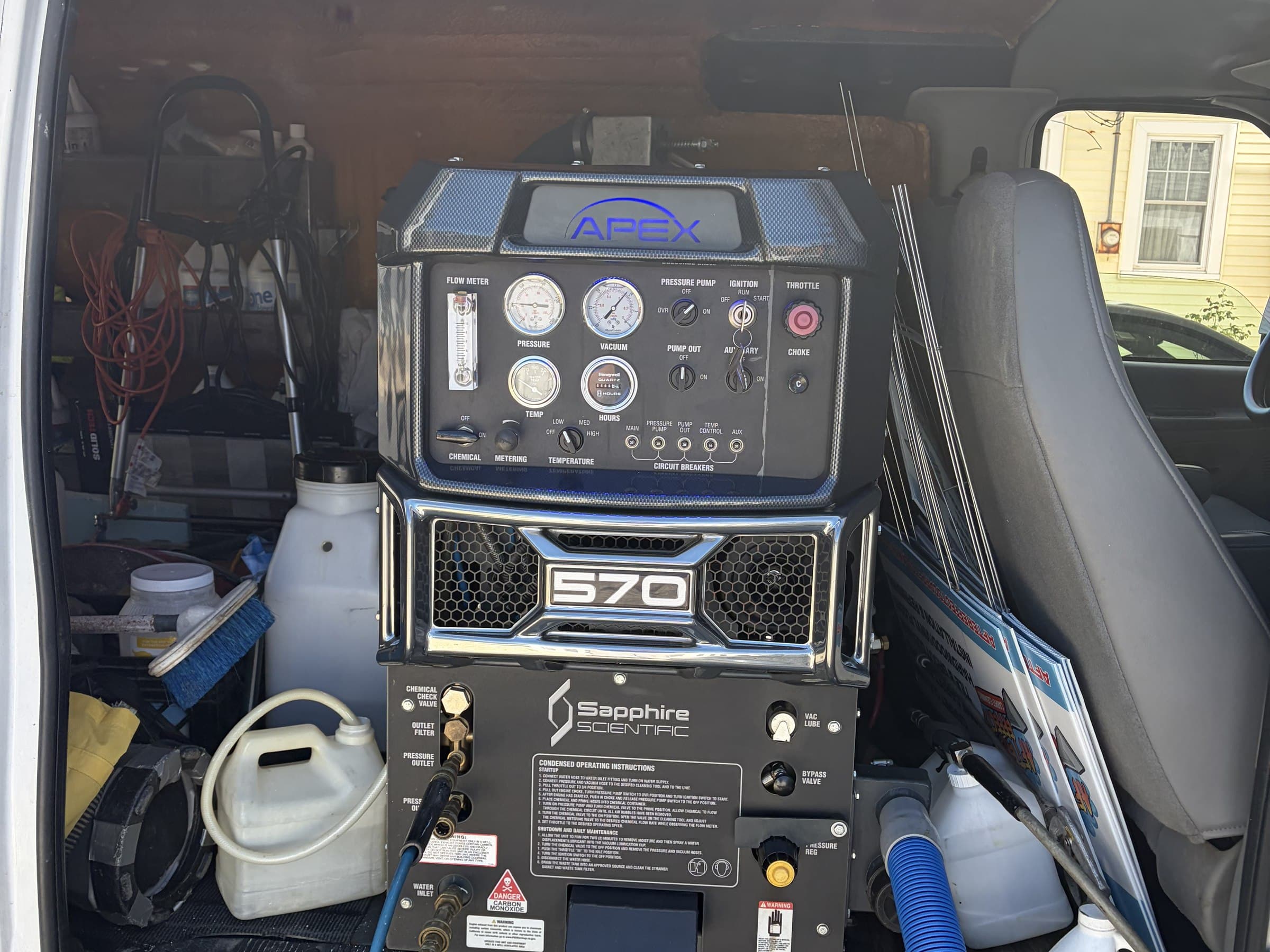 Truck-mounted carpet cleaning equipment with coiled hoses inside the After Effects work van