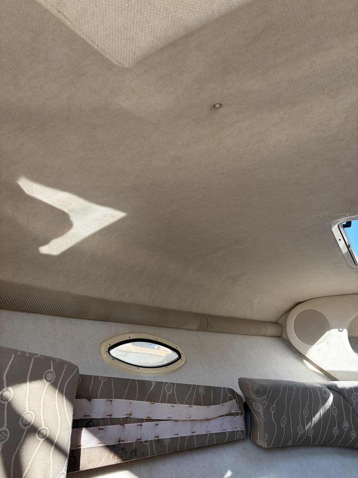 Boat cabin headliner cleaned bright, beside the same cabin's stained headliner before cleaning